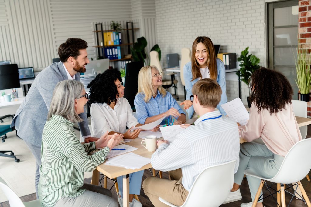 A diverse group of professionals engaged in a team meeting in a well-lit coworking space, fostering collaboration and generating creative solutions.