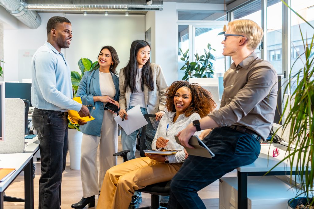 Group of young professionals collaborating and sharing ideas during a productive meeting in a bright and modern coworking space