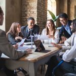 Group of multiethnic businesspeople discussing about financial strategy, renewable power, sustainable innovation project and environmental economical issues - business, sustainability interracial lifestyle concept
