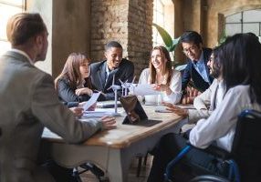 Group of multiethnic businesspeople discussing about financial strategy, renewable power, sustainable innovation project and environmental economical issues - business, sustainability interracial lifestyle concept