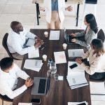 Business meeting, presentation and people above for conference, seminar or workshop in corporate training. Professional black woman, manager or speaker speaking to clients, employees or company staff