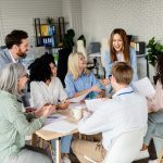 A diverse group of professionals engaged in a team meeting in a well-lit coworking space, fostering collaboration and generating creative solutions.