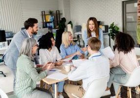 Collaborative coworkers brainstorming ideas at a group meeting in a stylish modern office space during daylight A diverse group of professionals engaged in a team meeting in a well-lit coworking space, fostering collaboration and generating creative solutions.