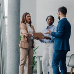 Business colleagues reviewing documents and discussing work in a modern office environment