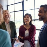 Group of multiethnic group of people sharing a joyful moment in the office. Professional team laughing and enjoying each other's company. Colleagues bonding and connecting during a casual meeting or break.