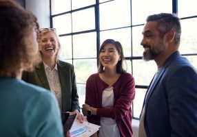 Group of multiethnic group of people sharing a joyful moment in the office. Professional team laughing and enjoying each other's company. Colleagues bonding and connecting during a casual meeting or break.