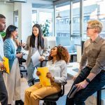 Multi-ethnic colleagues discussing project details, sharing ideas, and working together in a modern coworking office