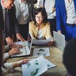 Business entrepreneurs people working at team meeting. Multiethnic colleagues inside bank workplace. Focus on Asian woman face