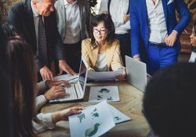 Business entrepreneurs people working at team meeting. Multiethnic colleagues inside bank workplace. Focus on Asian woman face