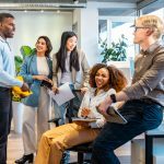 Group of young professionals collaborating and sharing ideas during a productive meeting in a bright and modern coworking space