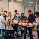 Cheerful diverse office people group talking and enjoying teamwork during staff meeting. Happy multiracial coworkers have fun working together at office brainstorming. Teamwork concept.