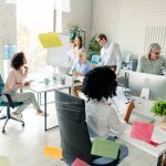 Friendly and diverse group of colleagues working together in a modern and bright office environment.