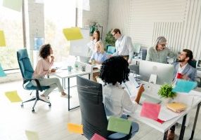 Friendly and diverse group of colleagues working together in a modern and bright office environment.