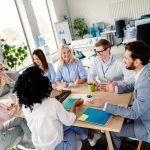 Colleagues in a professional office setting engage in a productive meeting filled with teamwork and creative energy