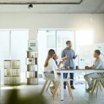 Group of diverse businesspeople having a meeting in an office at work. Young african american businessman talking while doing a presentation at a table for coworkers. Businesspeople planning together