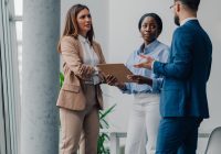 Business colleagues reviewing documents and discussing work in a modern office environment