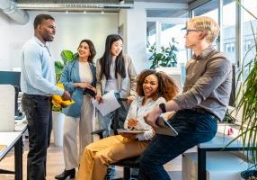 Group of young professionals collaborating and sharing ideas during a productive meeting in a bright and modern coworking space